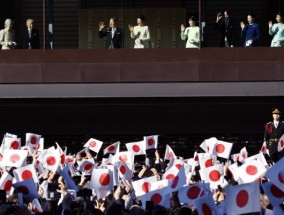 日本天皇和他的家人迎接新年在皇宫挥舞国旗的人群